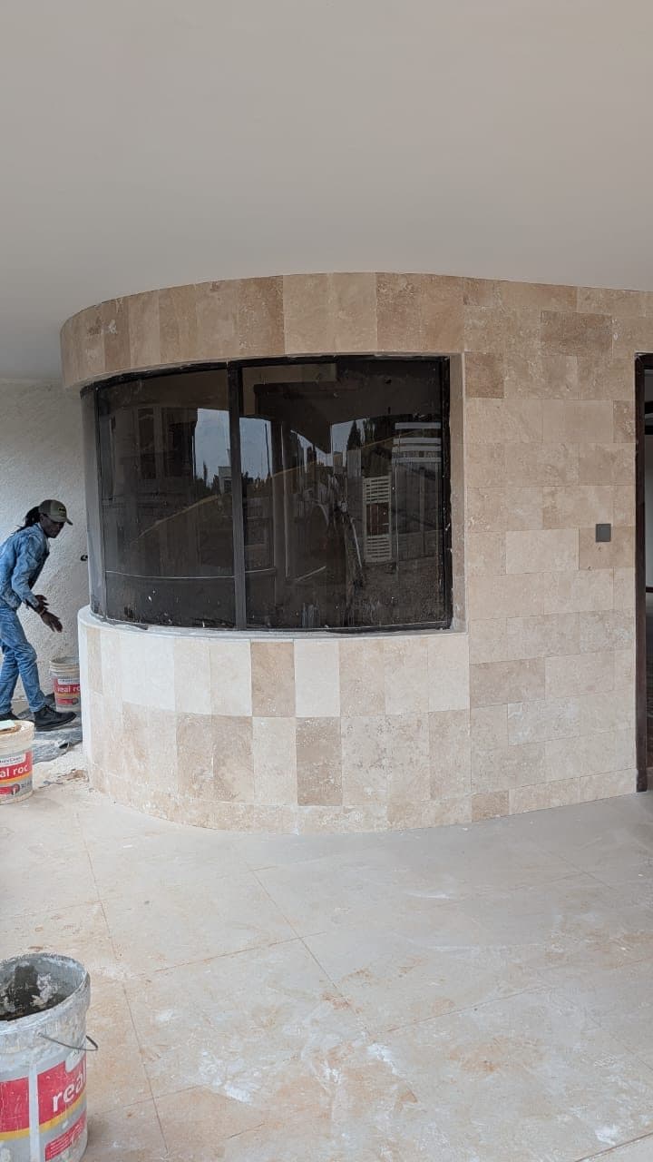 Curved travertine-clad bay with curved glazing on the villa terrace - built by Royalwoods Interiors, Nairobi