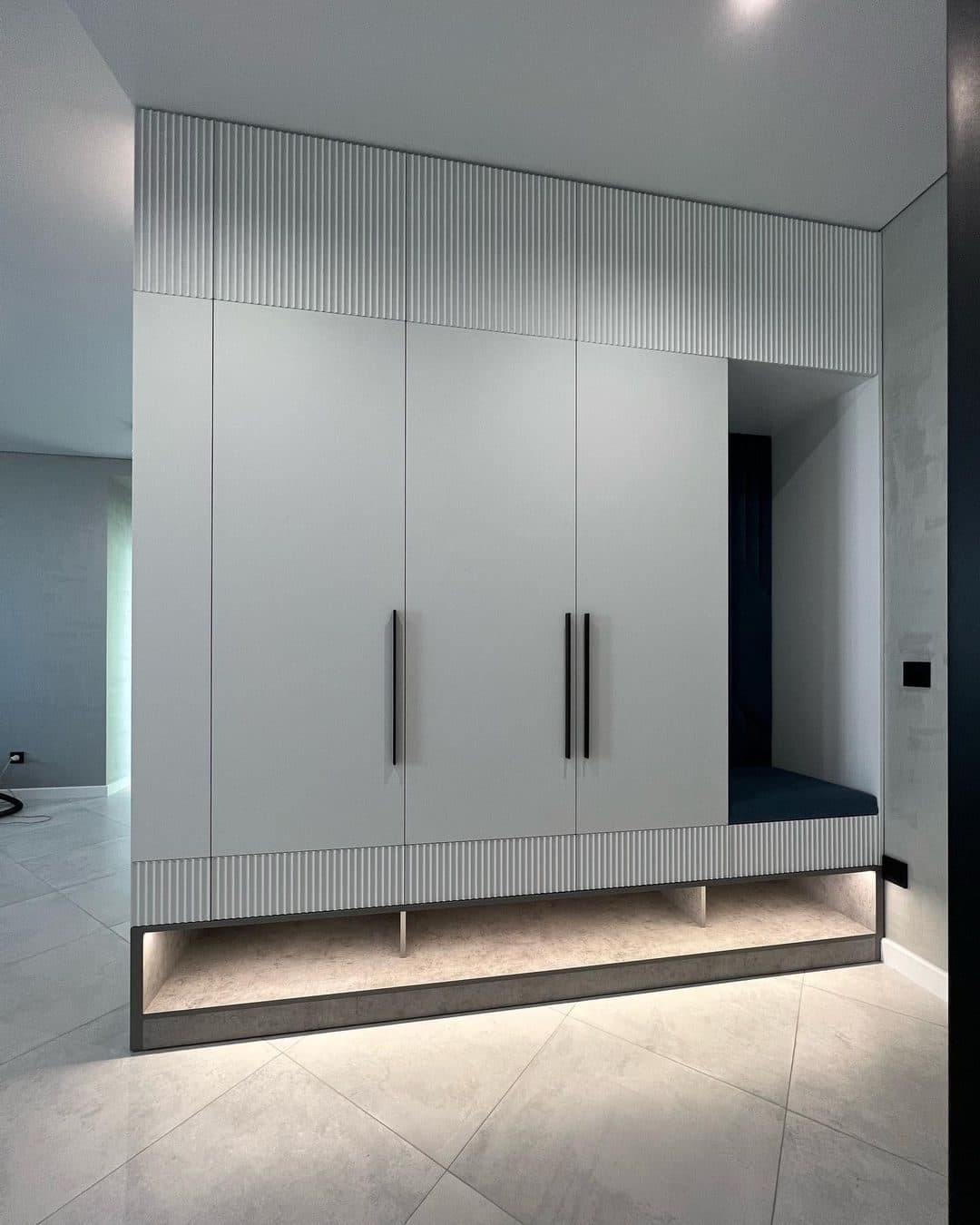 Fluted entry wardrobe with lit bench nook for daily ritual - bespoke joinery by Royalwoods Interiors, Nairobi