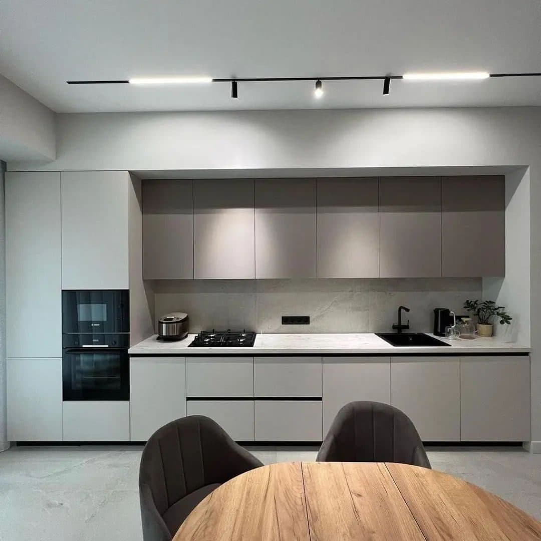 Greige minimalist kitchen with black-framed dining set and track lighting - bespoke joinery by Royalwoods Interiors, Nairobi