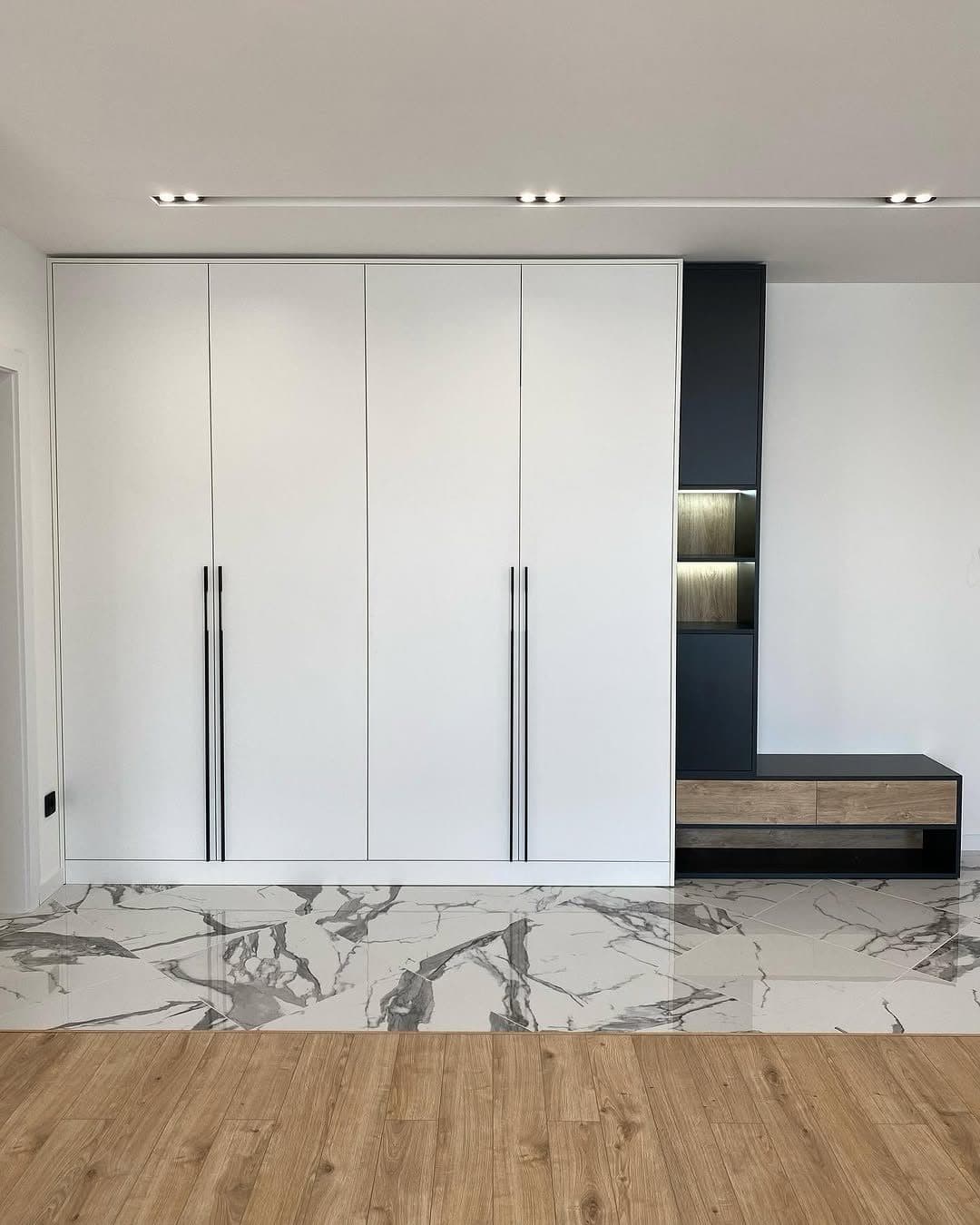 White storage wall with black display column and floating oak bench at Tatu City