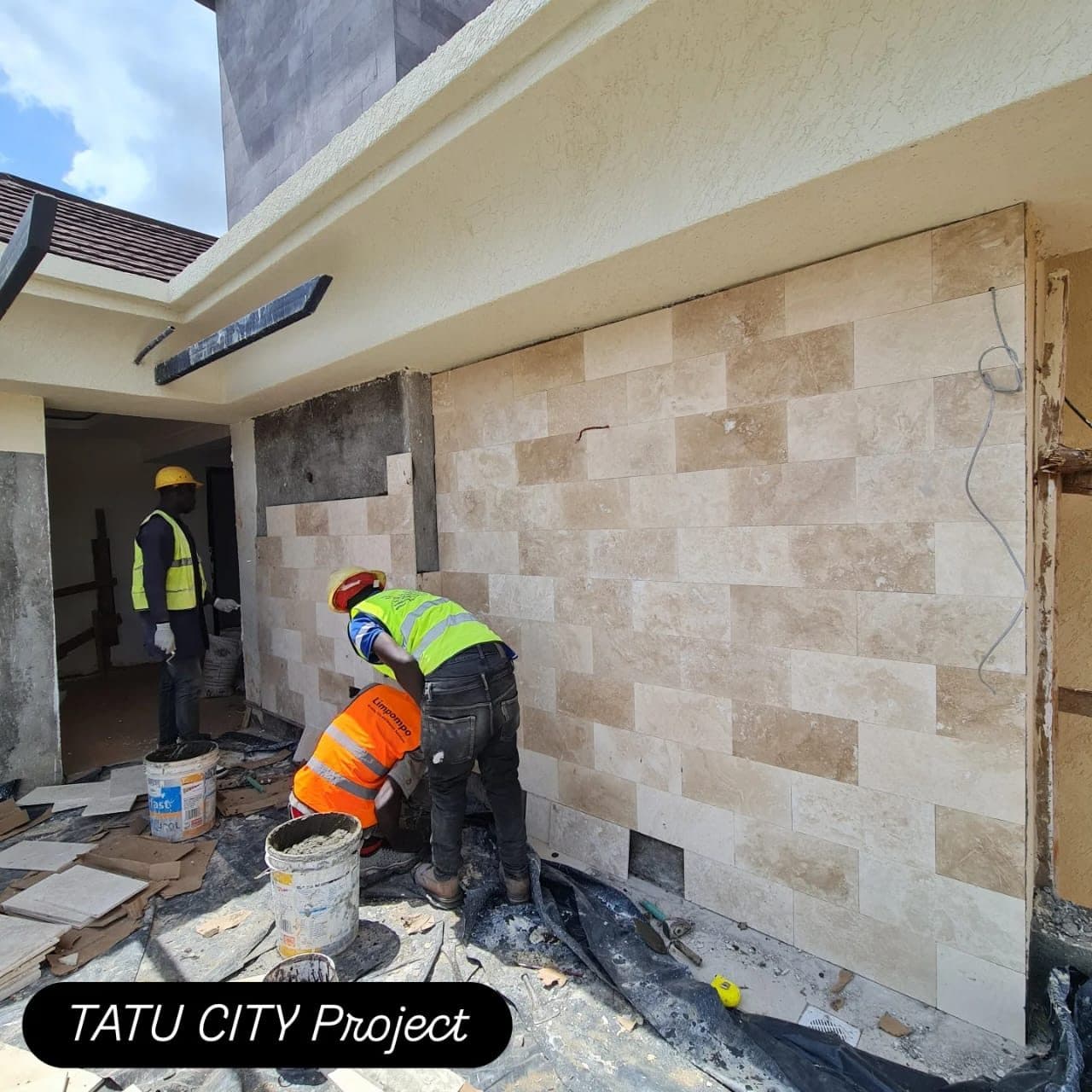 Masons dressing natural stone cladding on the Tatu City project facade