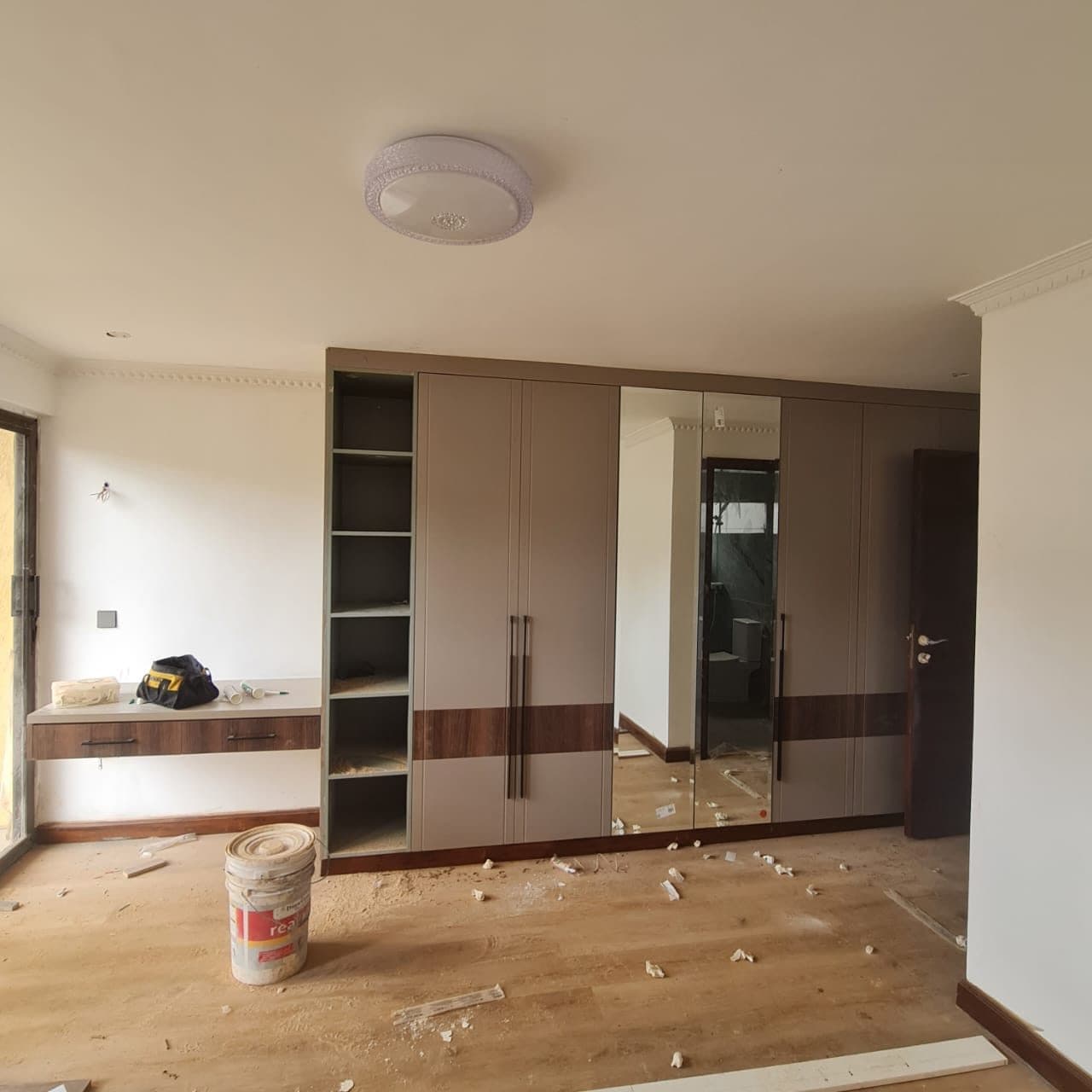 Taupe wardrobe and dressing bench mid-install, cornice already run - bespoke joinery by Royalwoods Interiors, Nairobi
