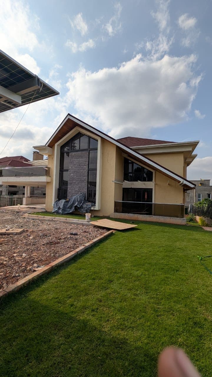Villa gable end with full-height glazing, stone feature column and solar pergola - built by Royalwoods Interiors, Nairobi