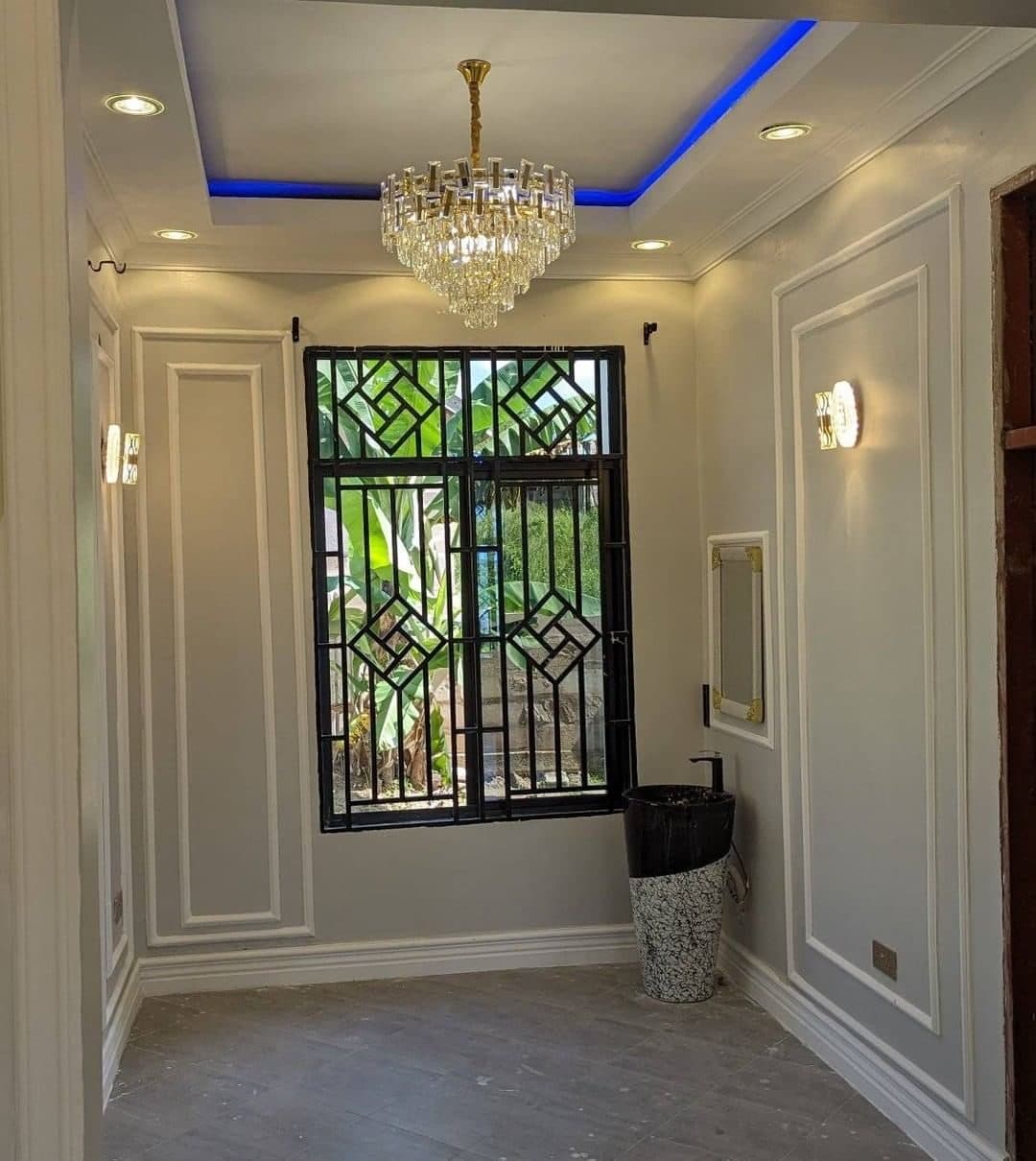 Classical wall panelling and crystal chandelier against fretwork window grilles, Nairobi