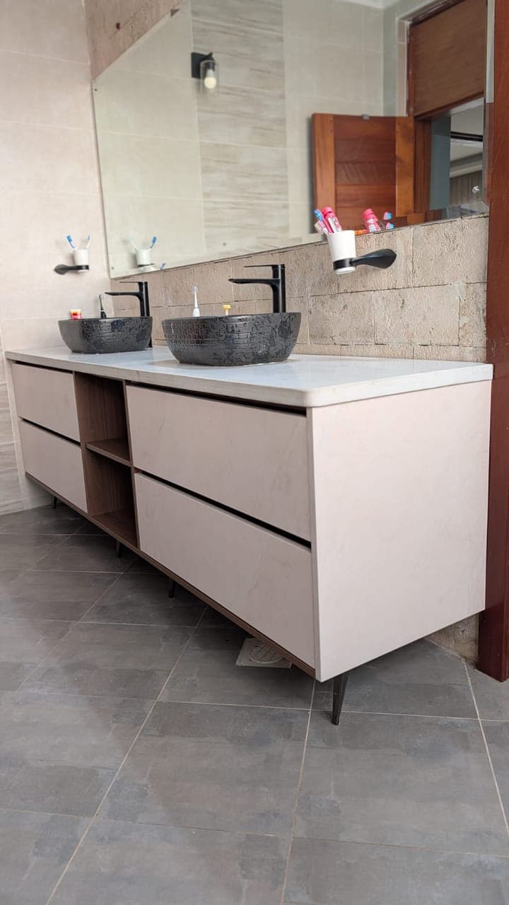The vanity from the doorway — handleless drawers beneath a stone top - bespoke joinery by Royalwoods Interiors, Nairobi