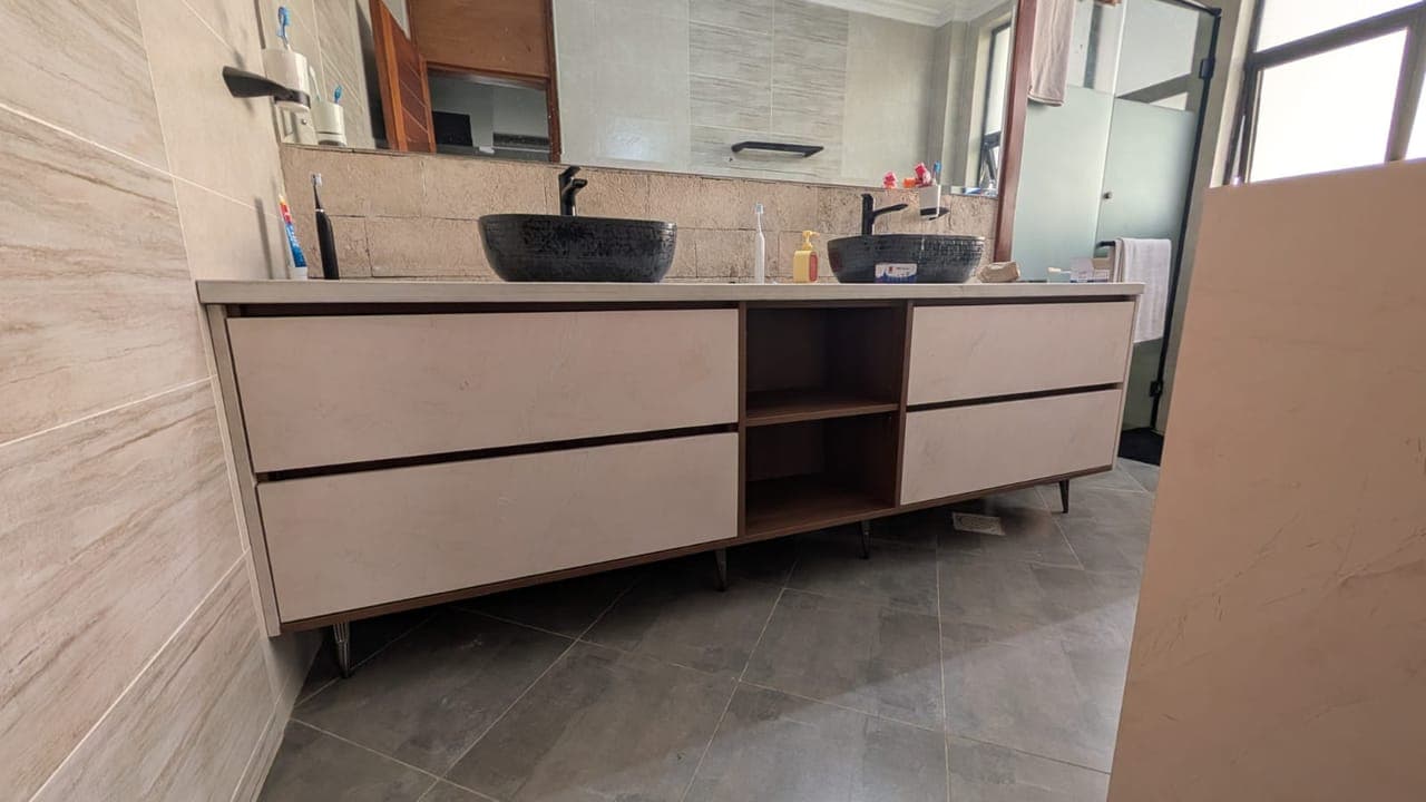 An open central niche breaks the run and holds folded towels - bespoke joinery by Royalwoods Interiors, Nairobi