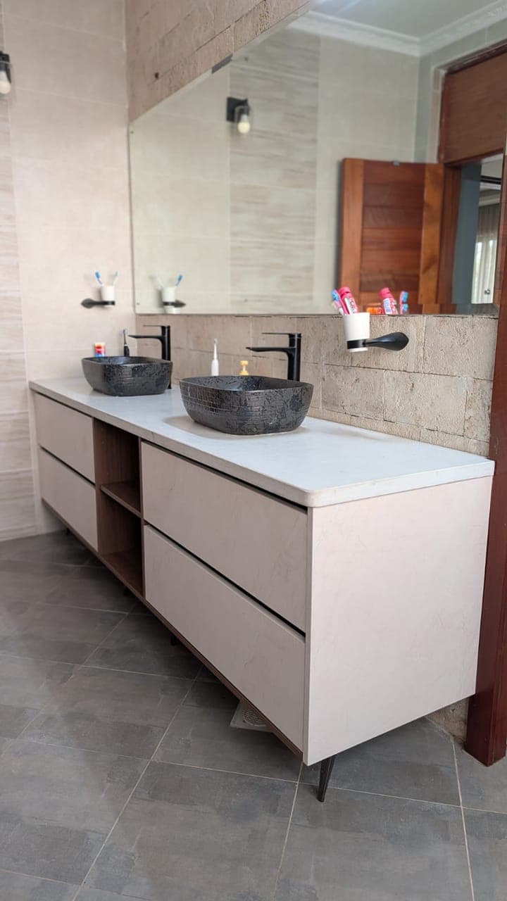 Greige double vanity with twin black stone vessel basins under a full-width mirror - bespoke joinery by Royalwoods Interiors, Nairobi