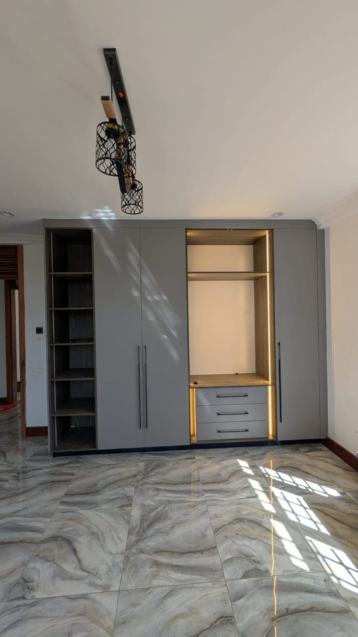 Open display bays beside a gold-trimmed drawer stack - bespoke joinery by Royalwoods Interiors, Nairobi