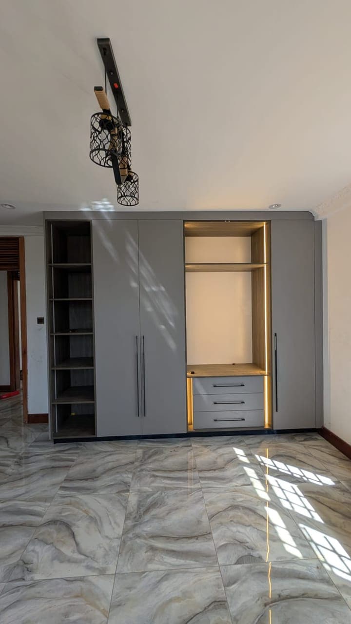 Grey wardrobe with gold-edged drawers, open hanging and display shelving - bespoke joinery by Royalwoods Interiors, Nairobi