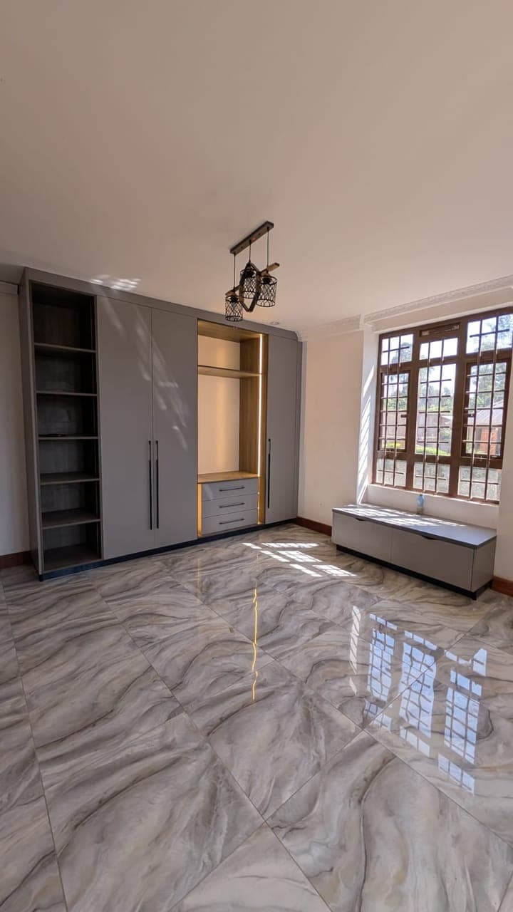 Grey wardrobe with open shelving and spotlight in a child's bedroom, Nairobi