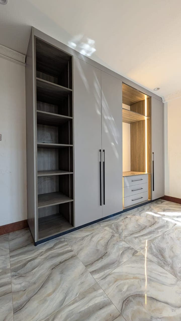 A walk-through wardrobe — shelving to one side, hanging to the other - bespoke joinery by Royalwoods Interiors, Nairobi