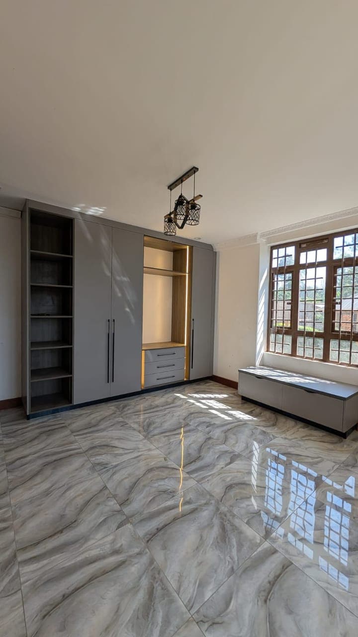 Grey wardrobe and window bench set over veined marble - bespoke joinery by Royalwoods Interiors, Nairobi