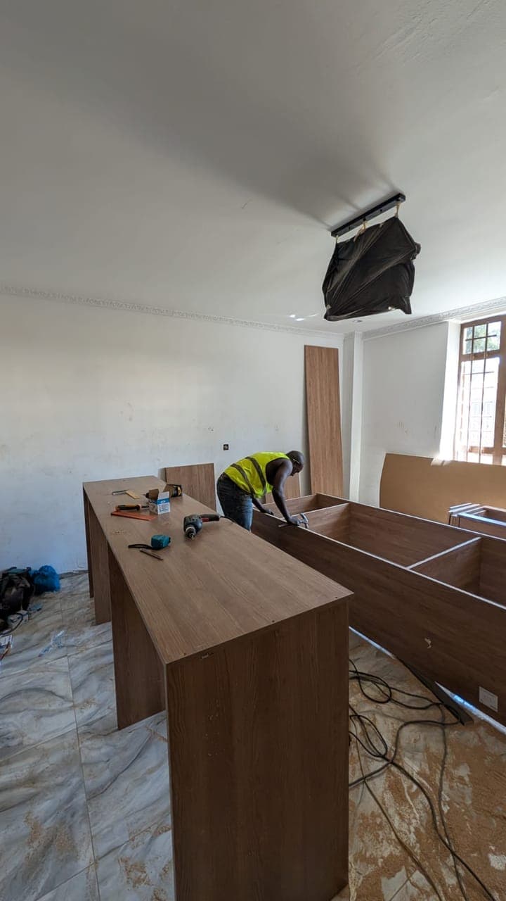 Levelling the island against the window wall during first fix - bespoke joinery by Royalwoods Interiors, Nairobi
