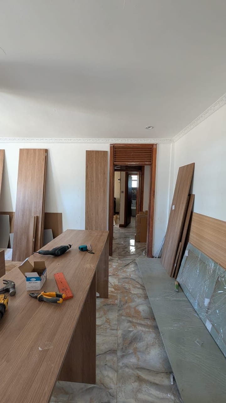 The long island run set out toward the corridor, before its countertop - bespoke joinery by Royalwoods Interiors, Nairobi
