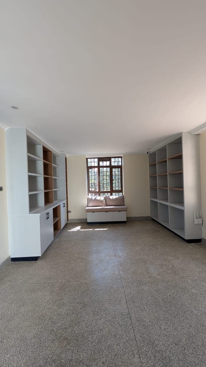 Built-in living room shelving with cabinets and window seat in Nairobi