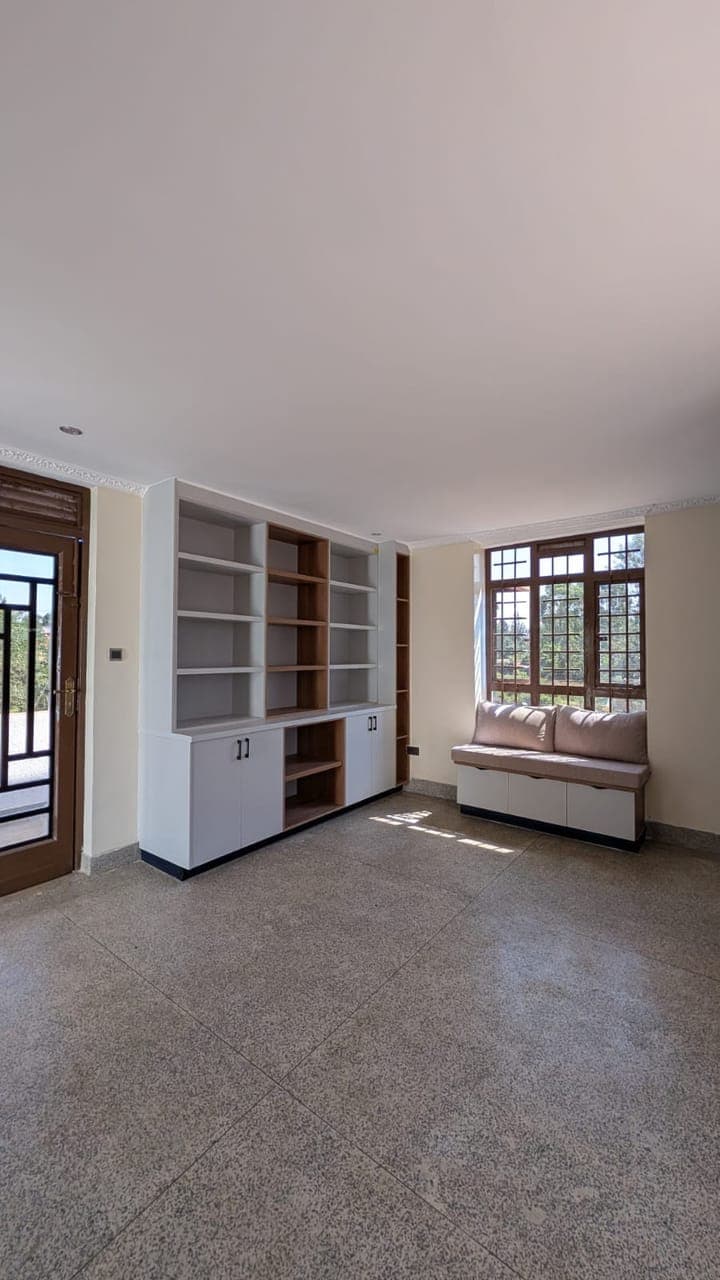 Living room with white built-in shelving and window seat, residential interior design in Nairobi