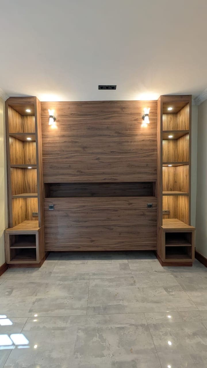 Walnut media wall with backlit display shelves in a Nairobi living room