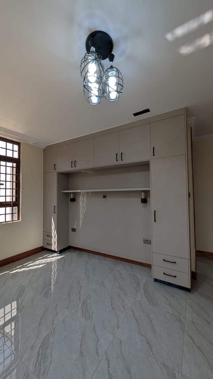 White fitted wardrobe — an open hanging bay beside a bank of drawers - bespoke joinery by Royalwoods Interiors, Nairobi