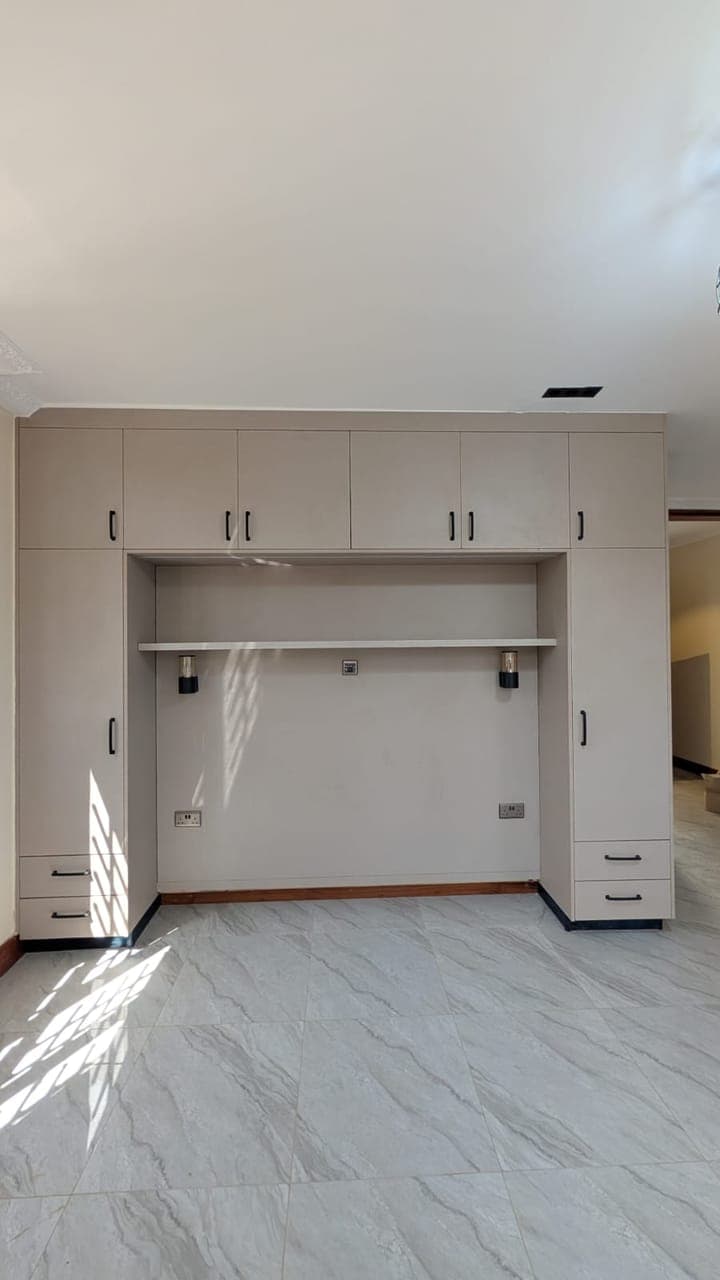 Full-height wardrobe with overhead cabinets above a long hanging rail - bespoke joinery by Royalwoods Interiors, Nairobi
