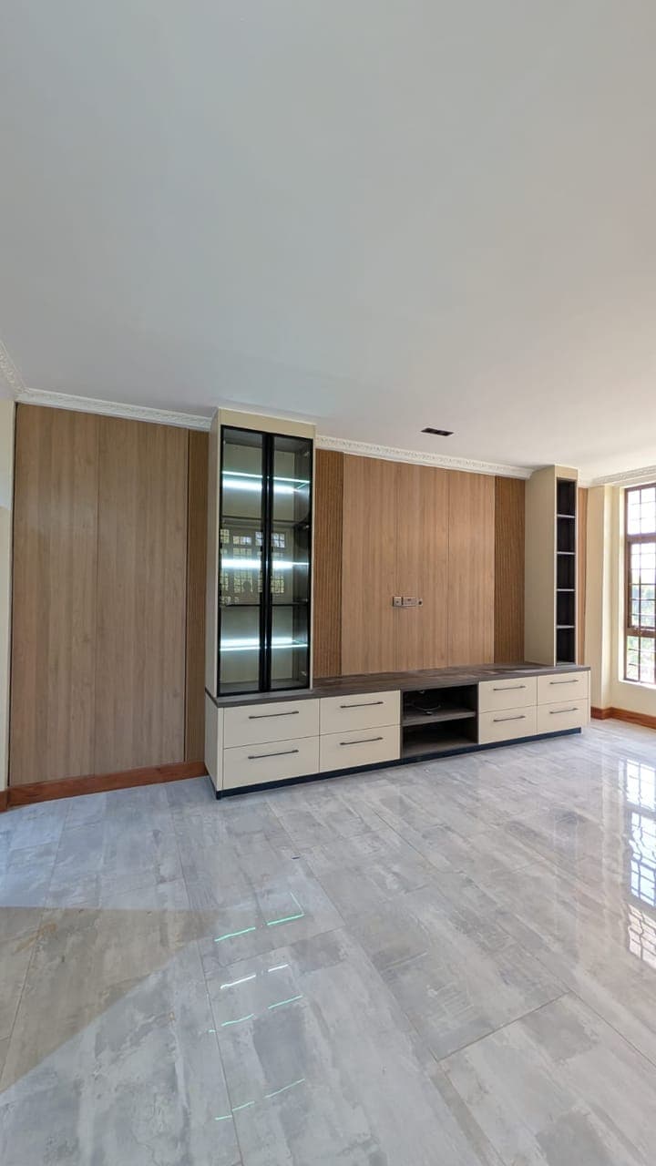 A low media console in wood and white, floating clear of a bright wall - bespoke joinery by Royalwoods Interiors, Nairobi