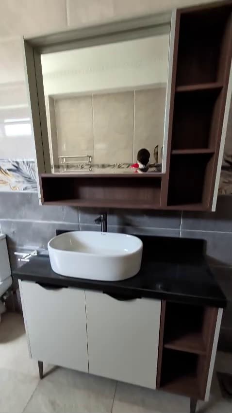 Greige double vanity with a black stone vessel basin and full-width mirror — Royalwoods Interiors, Nairobi
