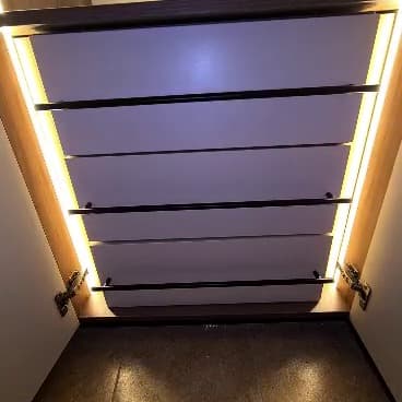 Warm strip lighting inside every hanging section, so the wardrobe works at 5am as well as at noon. — Royalwoods Interiors, Nairobi