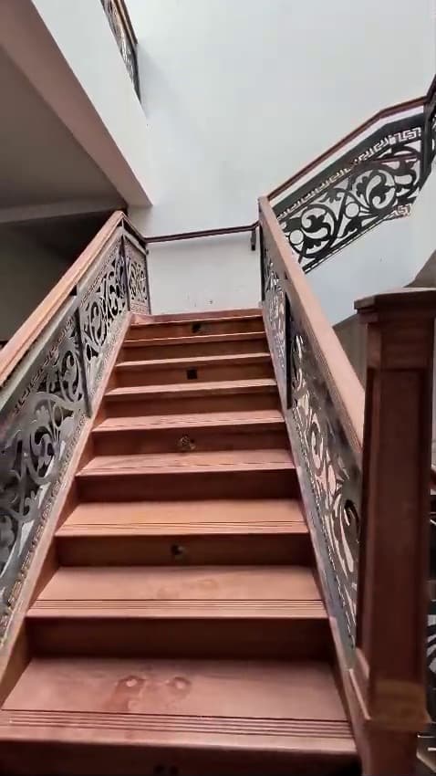 Mahogany staircase with laser-cut balustrade panels by Royalwoods Interiors
