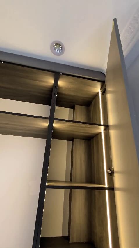 A walk-in closet with warm LED strip lighting in every bay — Royalwoods Interiors, Nairobi